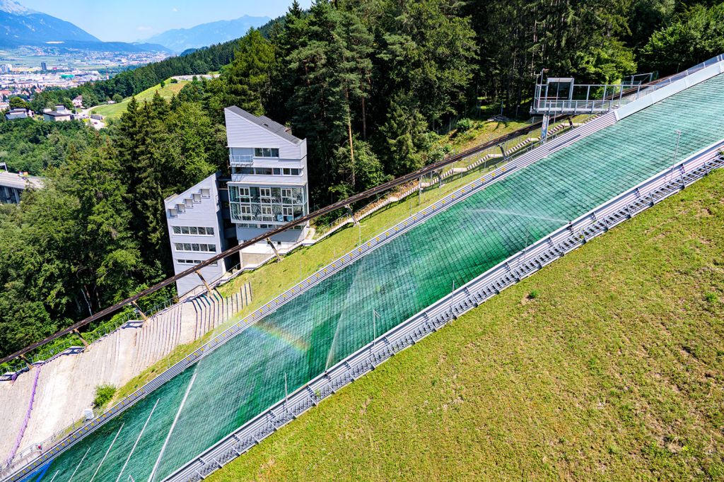 Punktzahl: 20 - So sieht der Aufsprunghang aus. Die Mattenschanze ist ganzjährig nutzbar. Die Matten müssen -wie hier mit Regenbogen zu sehen- regelmäßig bewässert werden. - © alpintreff.de - Christian Schön Punktzahl: 20 - So sieht der Aufsprunghang aus. Die Mattenschanze ist ganzjährig nutzbar. Die Matten müssen -wie hier mit Regenbogen zu sehen- regelmäßig bewässert werden. - © alpintreff.de - Christian Schön