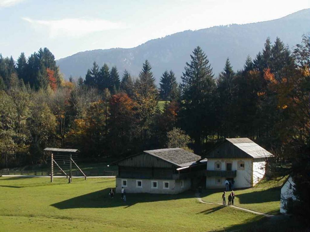 Wohnhaus aus Kartitsch, "Alter Segger" - Auf einer flachen Hangterrasse lag der Seggerhof im Tiroler Gailtal. Das Stubengetäfel ist um die 400 Jahre alt. Der Stubenofen wurde gleichzeitig als Backofen genutzt. Das bemalte, rechte Gebäude ist der "Brugger Kasten", der Getreidespeicher aus dem Jahr 1771. - © Museum Tiroler Bauernhöfe