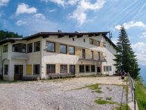 Ehemaliger Eingangsbereich der alten Hahnenkammbahn, die bis 2010 in Betrieb war. Der Zahn der Zeit hat sichtbar am Gebäude genagt, aber es steht derzeit noch immer. • © alpintreff.de / christian schön