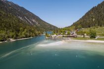 Die Seespitze vom Plansee. Im vorderen Bereich der Sandstrand, rechts hinten ist die terrassenförmige Anlage des Campingplatzes zu sehen.  • © Rene Paulweber, Naturparkregion Reutte