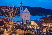 Der beschauliche Weihnachtsmarkt auf dem Goinger Kirchplatz wird umrahmt von der Kulisse des Wilden Kaisers. • © TVB Wilder Kaiser/Roland Defrancesco
