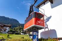 Die alte Hahnenkammbahn im Vordergrund, hinten an der Stütze die Gondeln der neuen Hahnenkammbahn.  • © skiwelt.de - Silke Schön