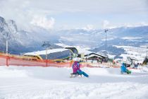 Im Vordergrund die Rodelpiste, links ist die Talstation der Peter Anich Bahn und daneben in der Bildmitte das Panoramarestaurant Stiglreith. • © Innsbruck Tourismus / Christian Vorhofer