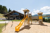 Die TOM Almhütte im Sommer mit Spielplatz für die Kinder. • © Hochkönig Tourismus GmbH